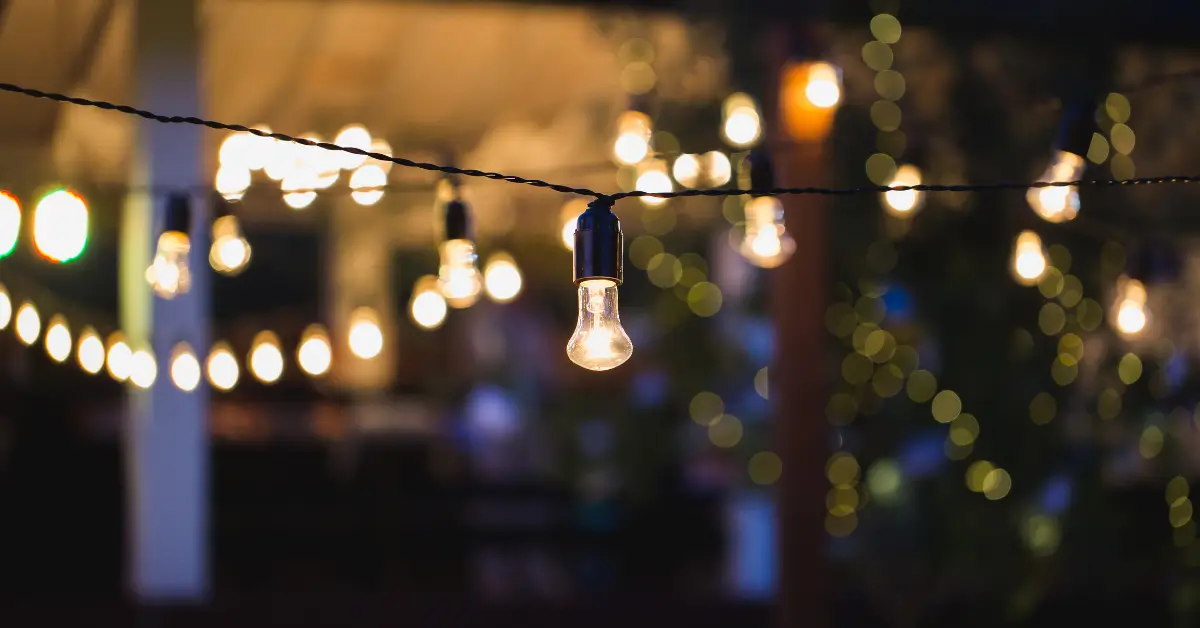 Outdoor string lights glowing at night, creating a warm and inviting ambiance for a backyard or patio space.